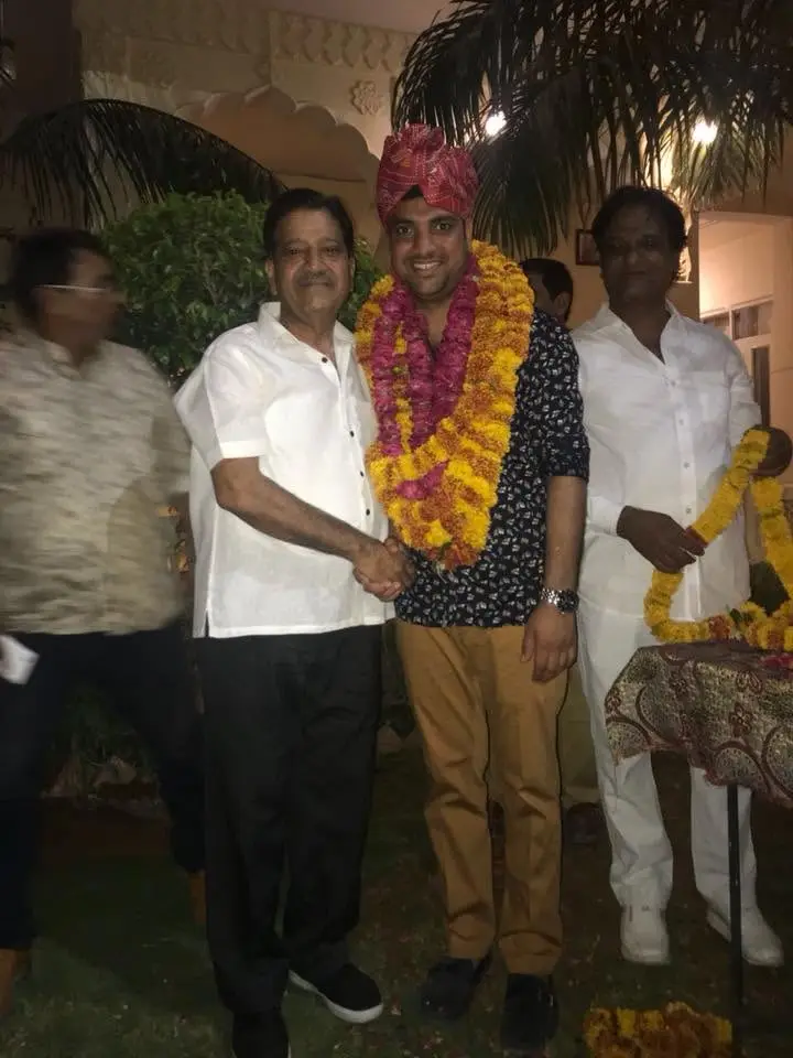 Gaurav Singh Tanwar in a turban and garland being congratulated by supporters